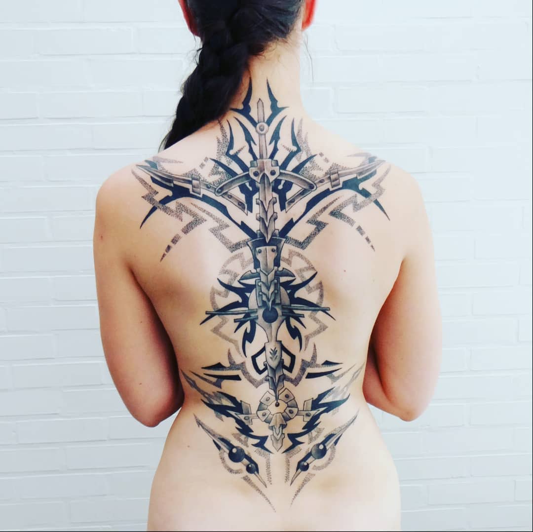Intricate cyberpunk tattoo covering the entire back, featuring symmetrical and mechanical designs